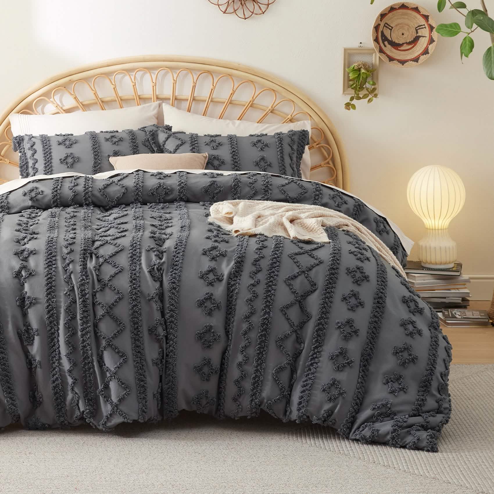 Dark gray microfiber duvet cover set with boho geometric tufted pattern on bed with rattan headboard.