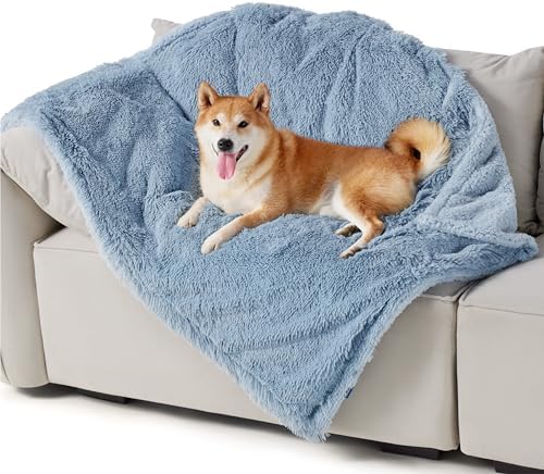 Shiba Inu dog relaxing on a plush, light blue waterproof pet blanket on a cream sofa, highlighting comfort and texture.