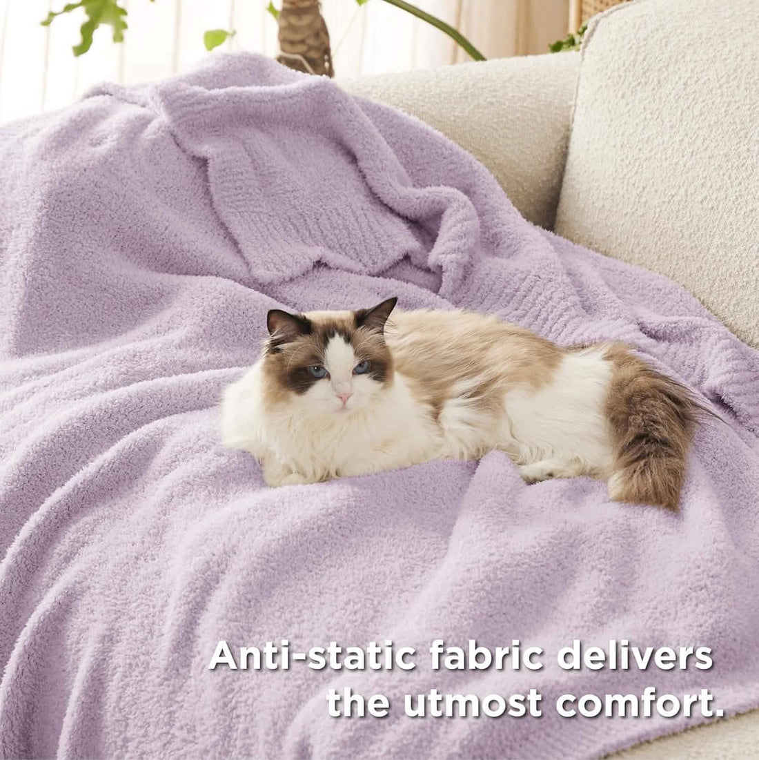 GentleSoft Feather Yarn Throw Blanket in light lavender draped over a cream chair, showcasing its plush texture.
