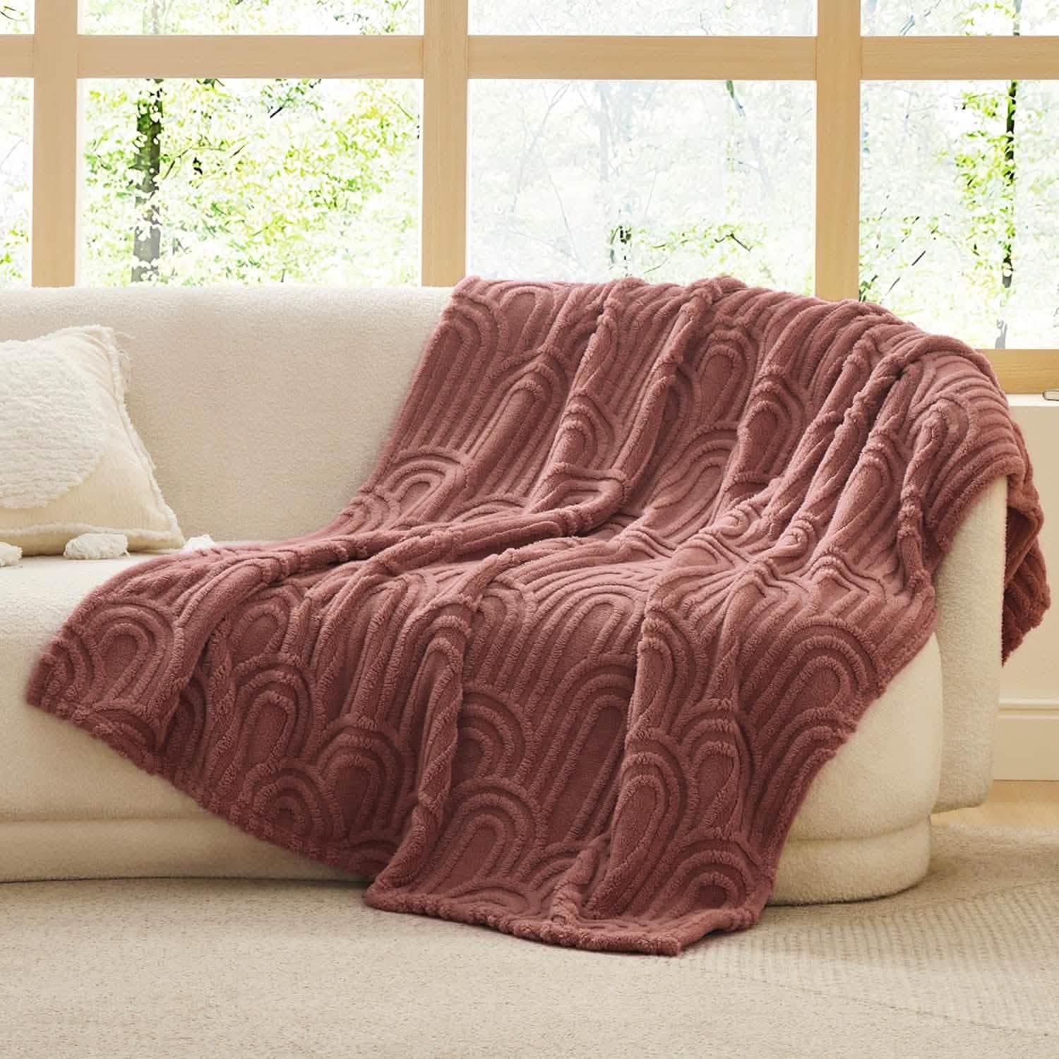 Rose GentleSoft Arch Sherpa Fleece Blanket with raised arch pattern draped over a cream sofa, home decor.