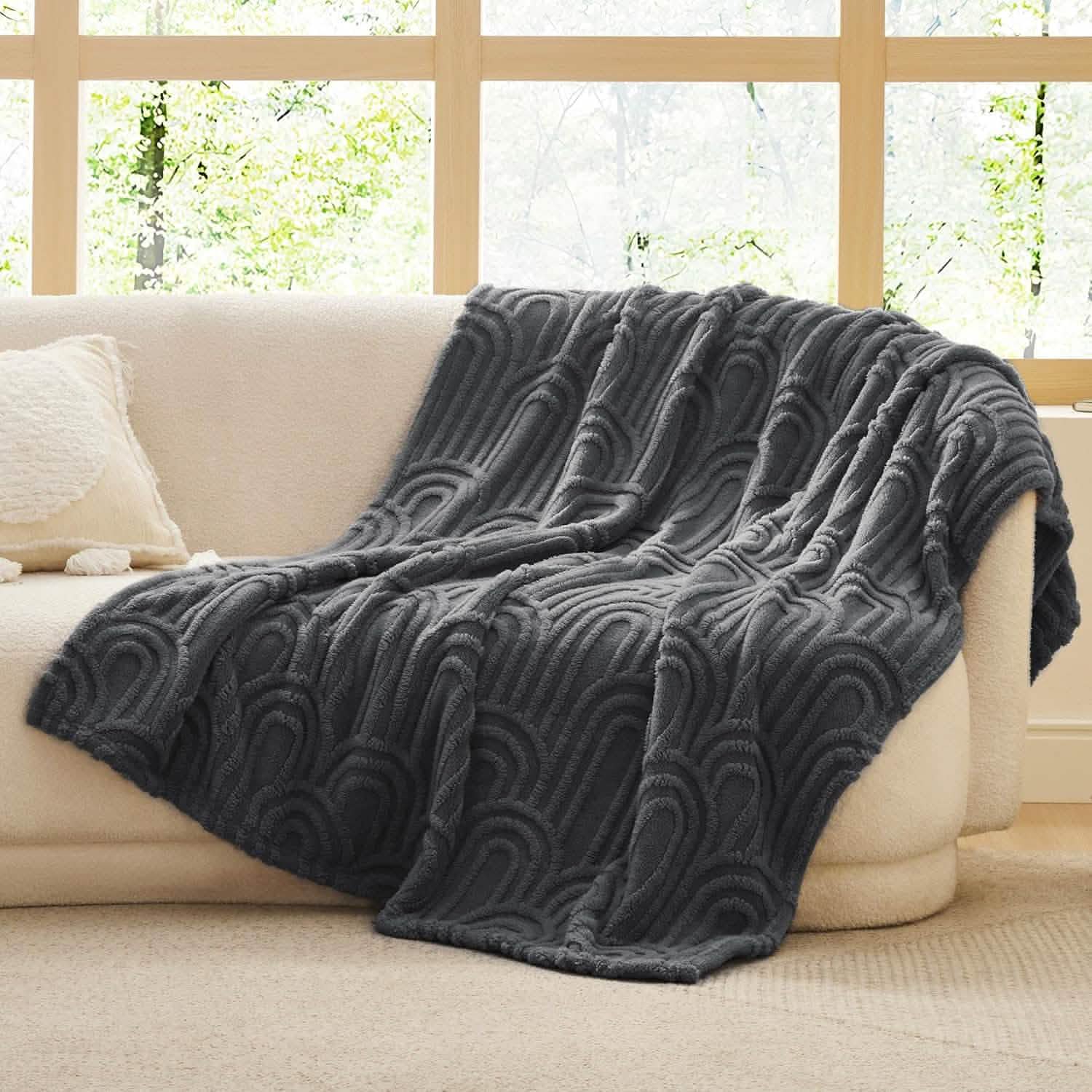 Dark gray GentleSoft Arch Sherpa blanket with raised arch pattern draped on cream sofa, plush texture, home decor.