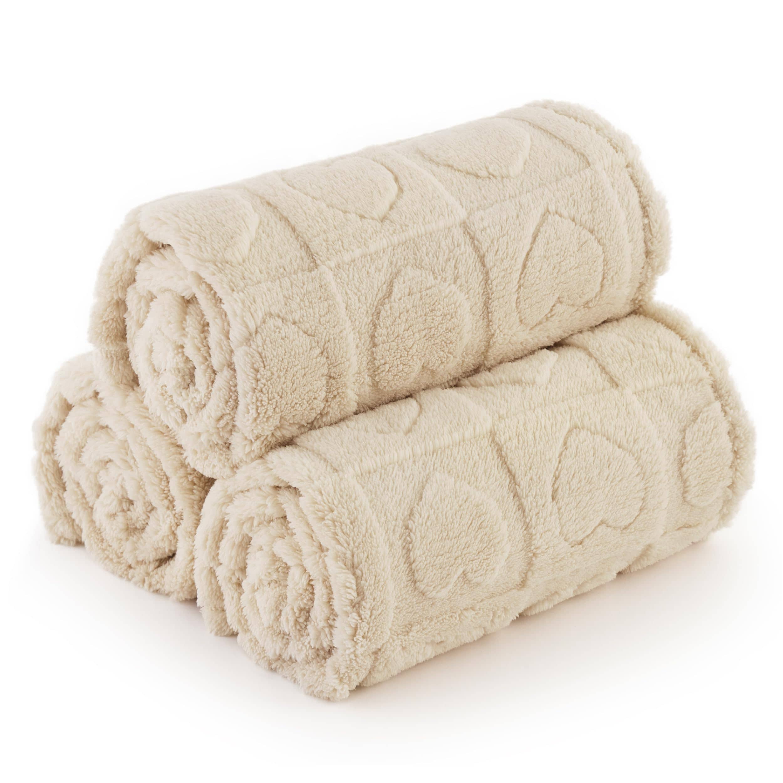 Three rolled beige Jacquard fleece pet blankets stacked, showcasing a soft plush texture and raised heart pattern.