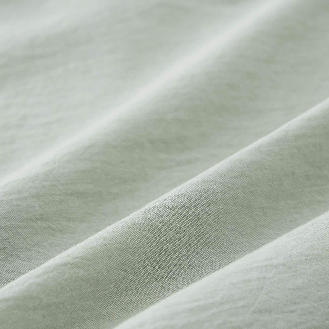 GentleSoft Prewashed Cotton Comforter Set in pale green with wrinkled texture and accent pillows on a bed.